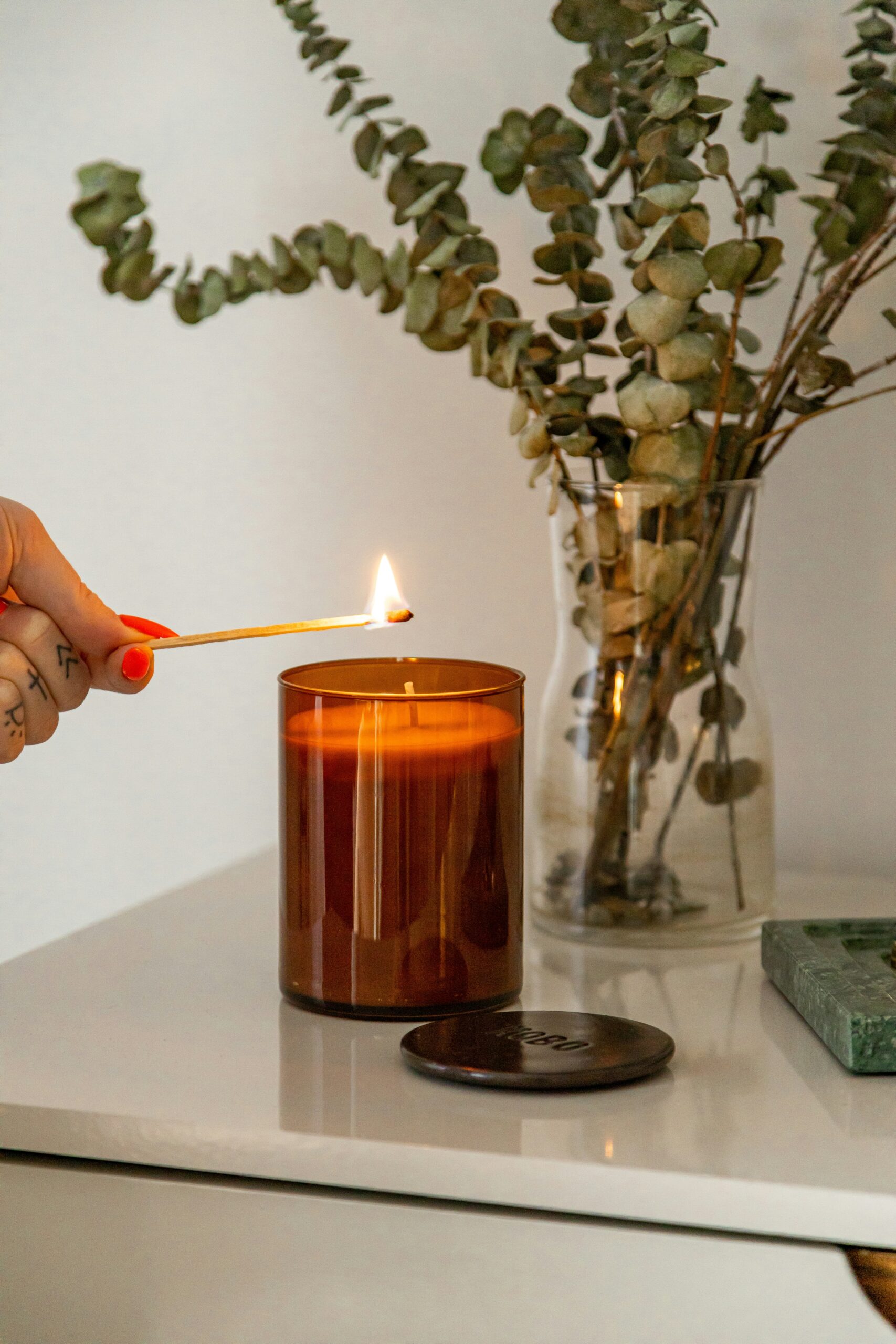 A warm, cozy scene with a lit candle next to a green plant, creating a calm afternoon atmosphere.