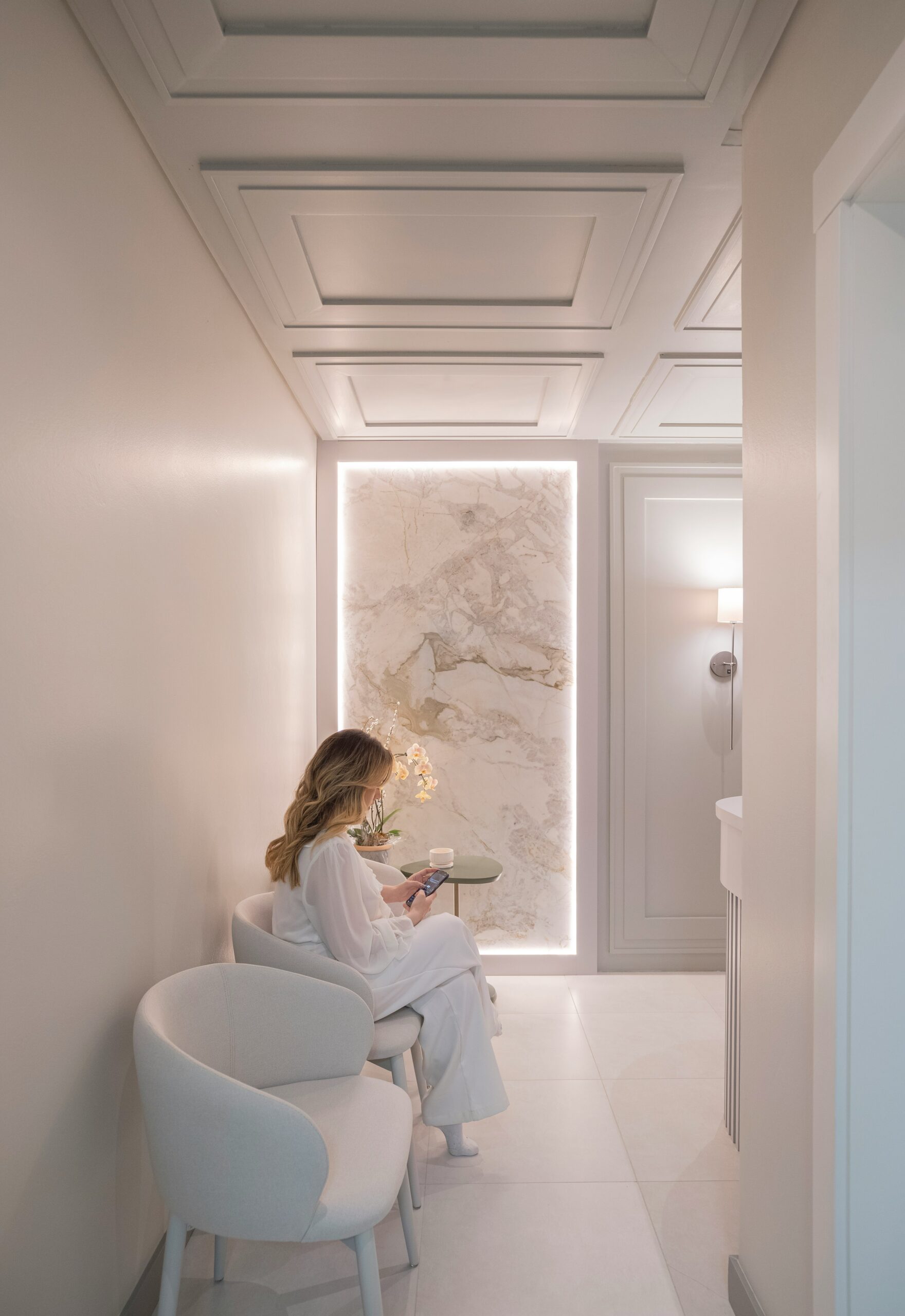 A woman sitting quietly in a softly lit room, reading with calm, reflective energy — a peaceful moment that captures the feeling of reconnecting with yourself in motherhood.